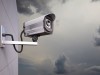 CCTV Camera attached to wall with clouds